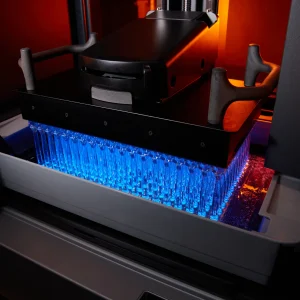 Bauplattform des Formlabs Form 4BL mit zahlreichen gedruckten Teilen über dem Harztank