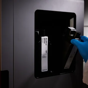 Hand im Laborhandschuh setzt eine Kartusche BioMed White Resin in den Formlabs Form 4BL ein
