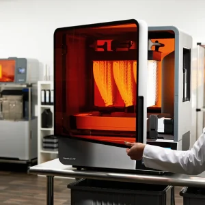 Laborantin öffnet die Abdeckung eines Formlabs Form 4BL im Medizinlabor